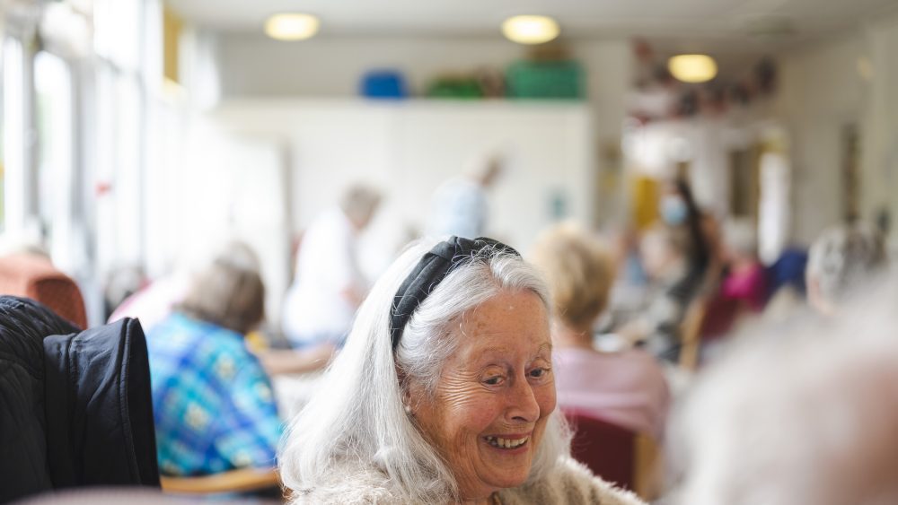 An older lady smiling in a café