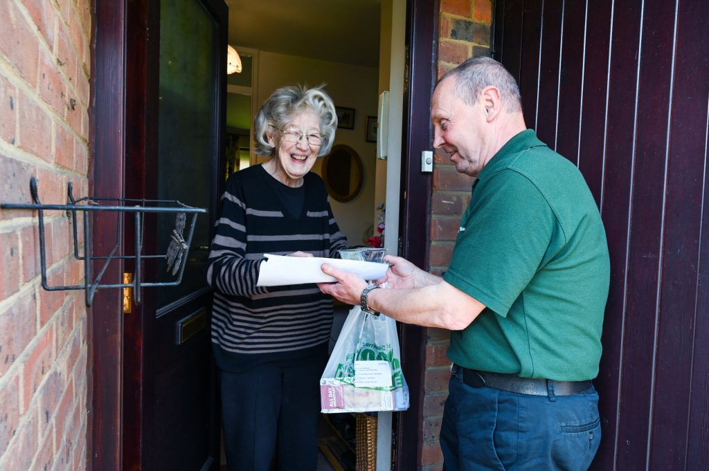An older lady receiving goods from delivery service
